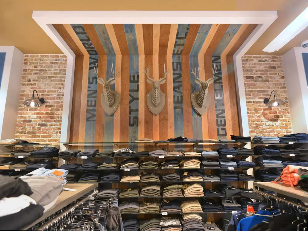 Hazi Hinam fashion department with menswear displays and decorative wood wall design.